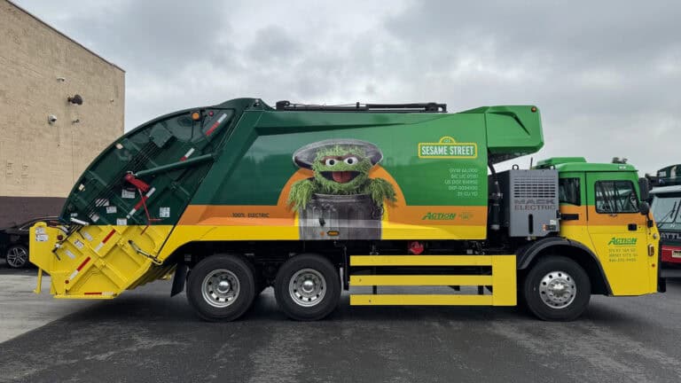 Oscar the Grouch featured on Action Carting Environmental Services’ first electric garbage truck in NYC, promoting recycling and clean streets with Sesame Street.