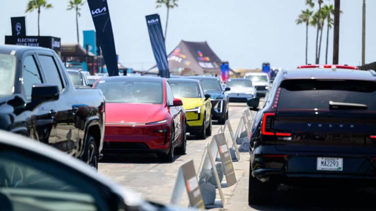 A lineup of electric vehicles, including a Tesla Model Y, Cadillac Lyriq, Volvo EX90, and others at Electrify Expo.