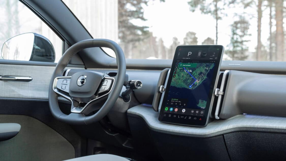 Interior view of the 2026 Volvo EX30 Cross Country showing the minimalist dashboard, Google-powered vertical infotainment touchscreen with navigation displayed, and multifunction steering wheel with integrated controls.
