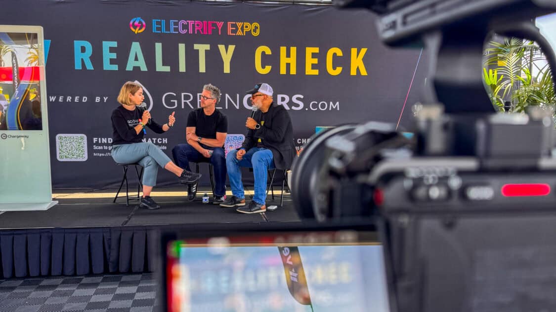 Lyubov Artemenko of GO TO-U on stage with Matt Teske and Diego Cardenas at Electrify Expo during an EV Reality Check session, powered by GreenCars, filmed for media coverage on electrification and EV technology