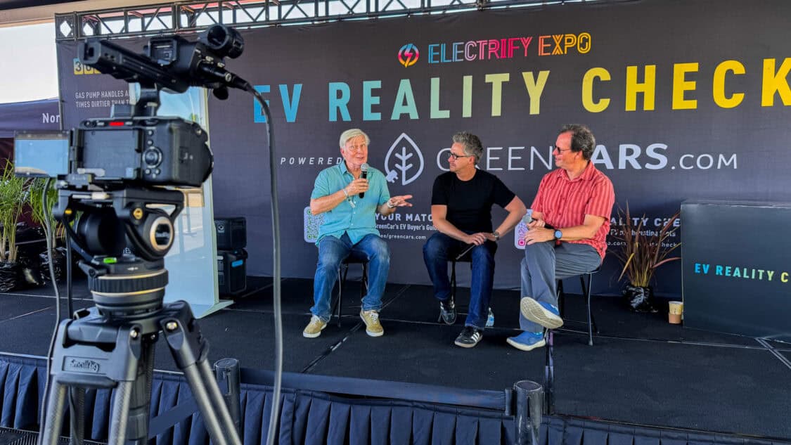 Tom Voelk of Driven Car Reviews on stage with Matt Teske and Dan O'Shea at Electrify Expo during an EV Reality Check session, powered by GreenCars, filmed for media coverage on electrification and EV technology