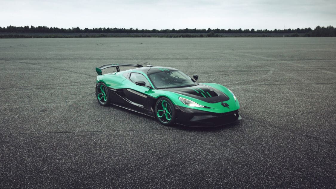 Rimac Nevera R stationary on open asphalt after its record-breaking test runs, highlighting its green-black color scheme and aggressive stance.