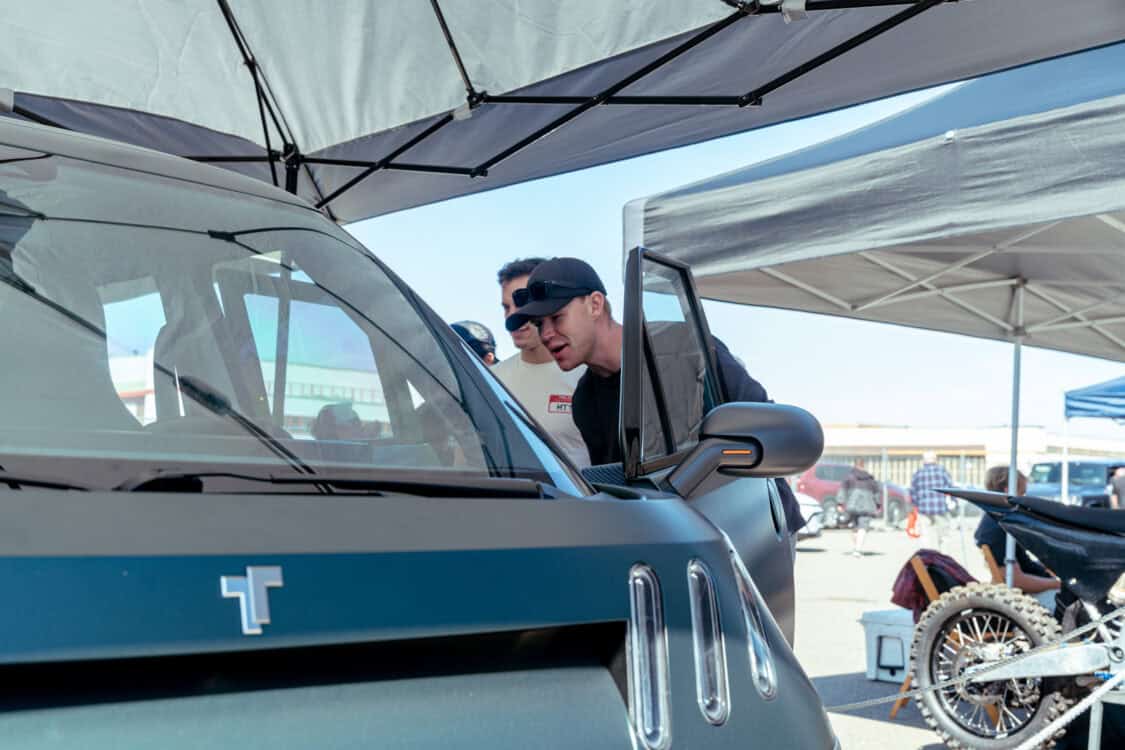 Attendees lean in to check out the TELO MT1 electric mini truck on display at Electrify Expo San Francisco.