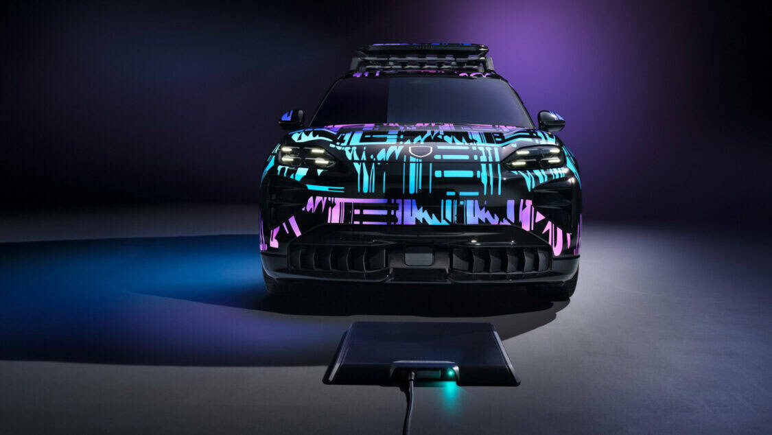 Porsche Cayenne Electric prototype aligned over a wireless charging pad glowing under purple and blue lighting.