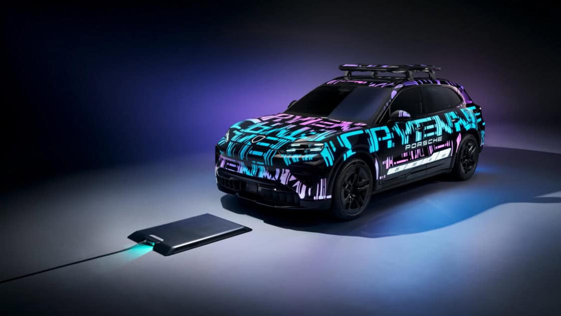 Porsche Cayenne Electric prototype aligned over a wireless charging pad glowing under purple and blue lighting.