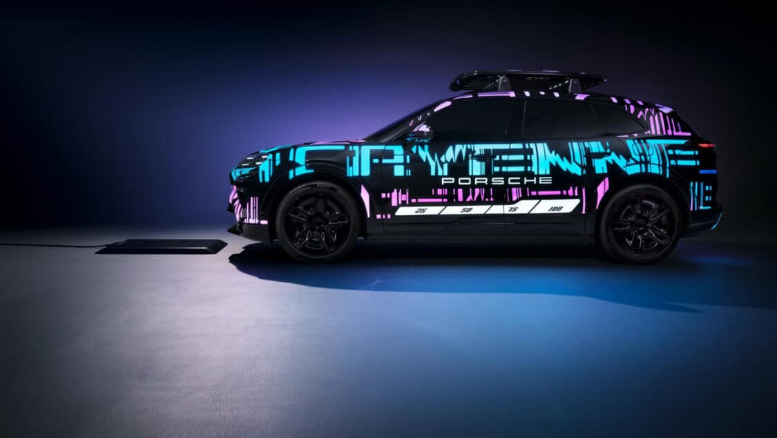 Porsche Cayenne Electric prototype aligned over a wireless charging pad glowing under purple and blue lighting.