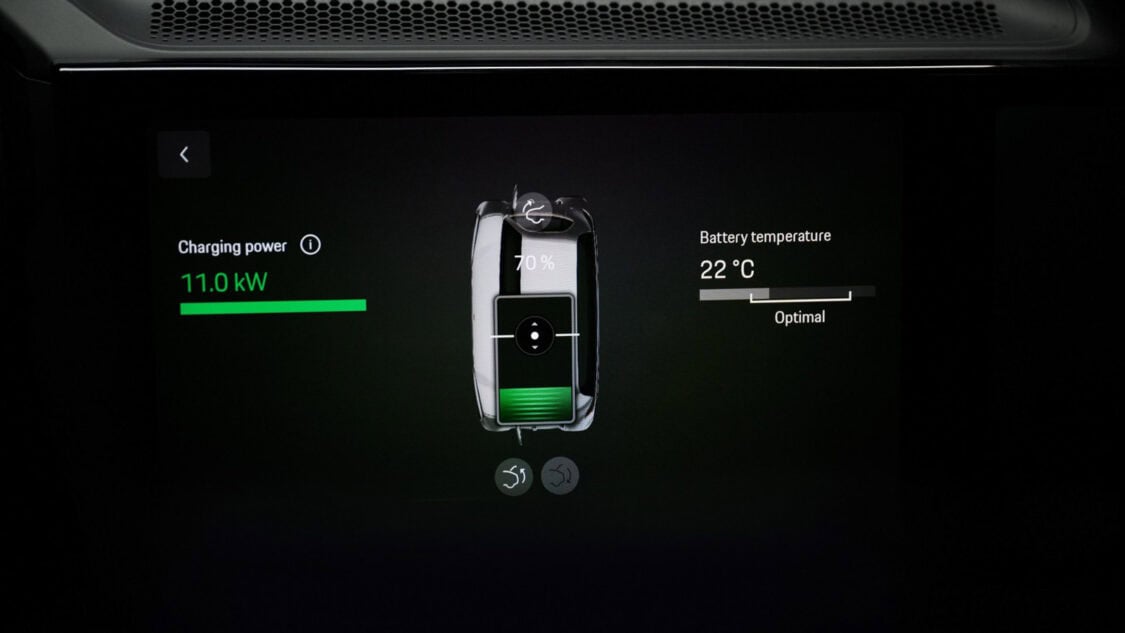 Porsche Cayenne Electric prototype aligned over a wireless charging pad glowing under purple and blue lighting.