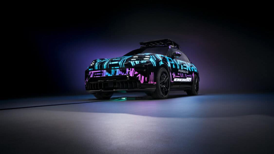 Porsche Cayenne Electric prototype aligned over a wireless charging pad glowing under purple and blue lighting.