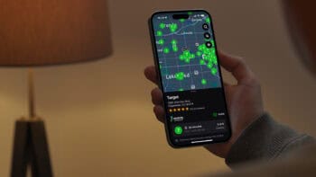 A person holding a smartphone displaying the Chargeway app with real-time EV charging prices and station locations near Lakewood, Colorado.