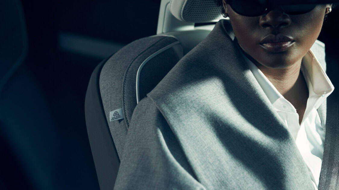 Close-up of a model wearing the Sergio Hudson car coat made from the same wool used in the Volvo EX90’s seat upholstery.