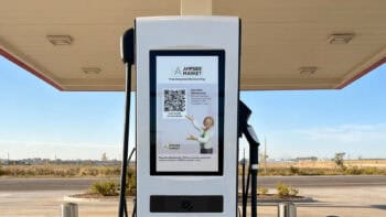 Electric Era RetailEdge fast charger displaying a loyalty program promotion on its touchscreen at a retail forecourt.