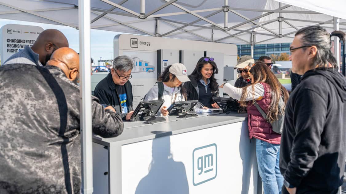 Visitors gather at the GM Energy booth at Electrify Expo learning how home charging and EV products can lower total cost of ownership.