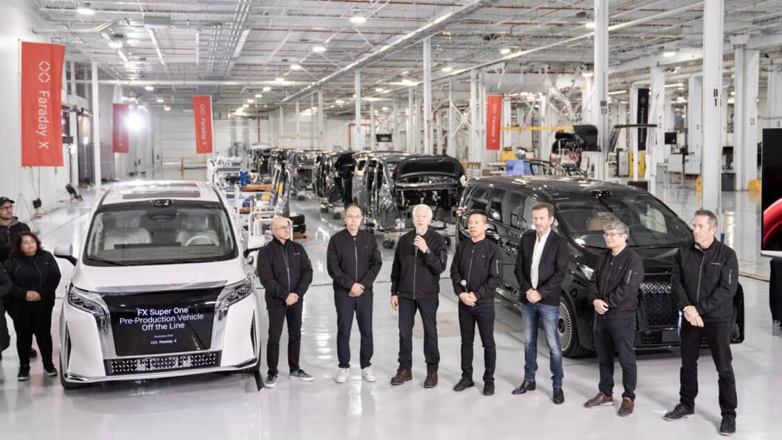Faraday Future team stands inside its California AI-Factory beside the first FX Super One pre-production electric MPV on the assembly line.