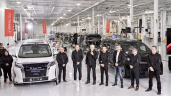 Faraday Future team stands inside its California AI-Factory beside the first FX Super One pre-production electric MPV on the assembly line.