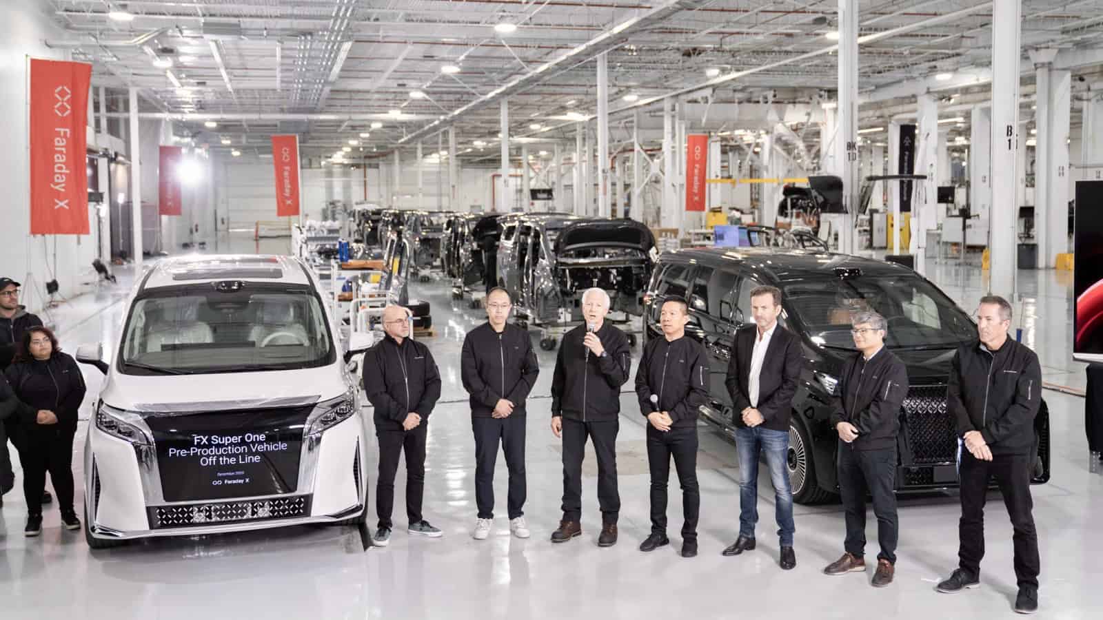 Faraday Future team stands inside its California AI-Factory beside the first FX Super One pre-production electric MPV on the assembly line.