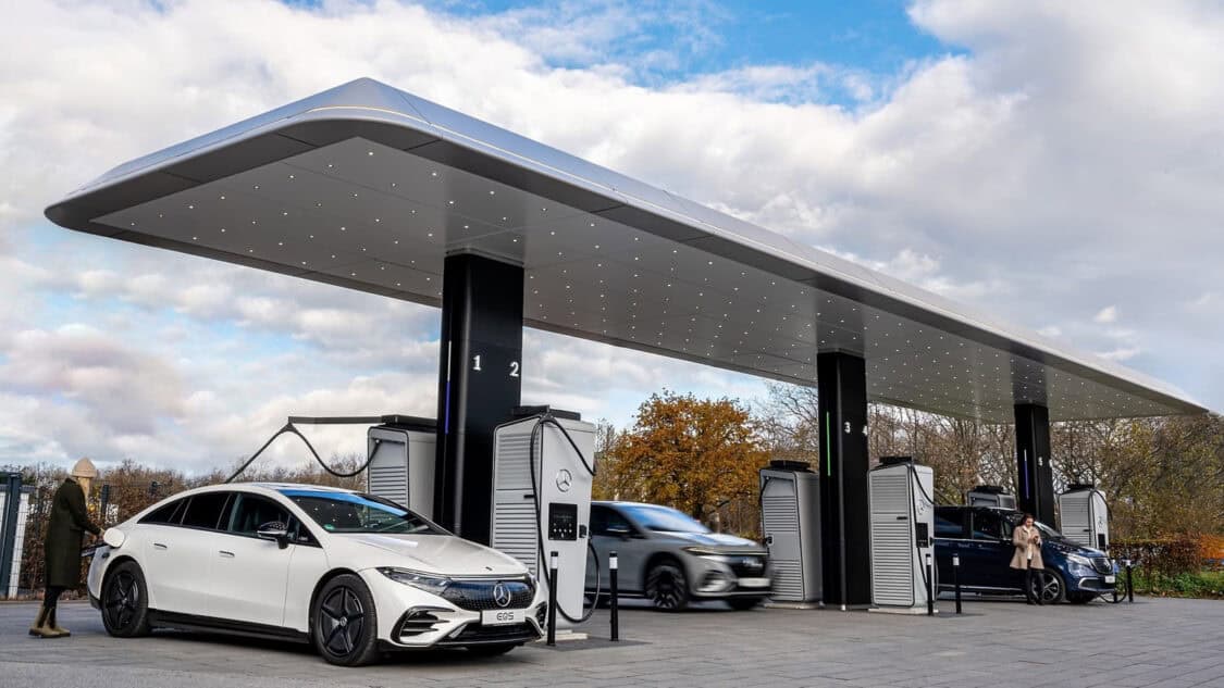 Mercedes-Benz opens its first European EV power hub, with electric vehicles connected to high-speed power units beneath a covered canopy at a retail-style location.