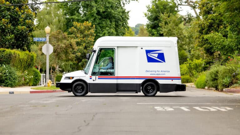 USPS electric mail truck driving through a neighborhood, highlighting the shift to cleaner holiday deliveries.