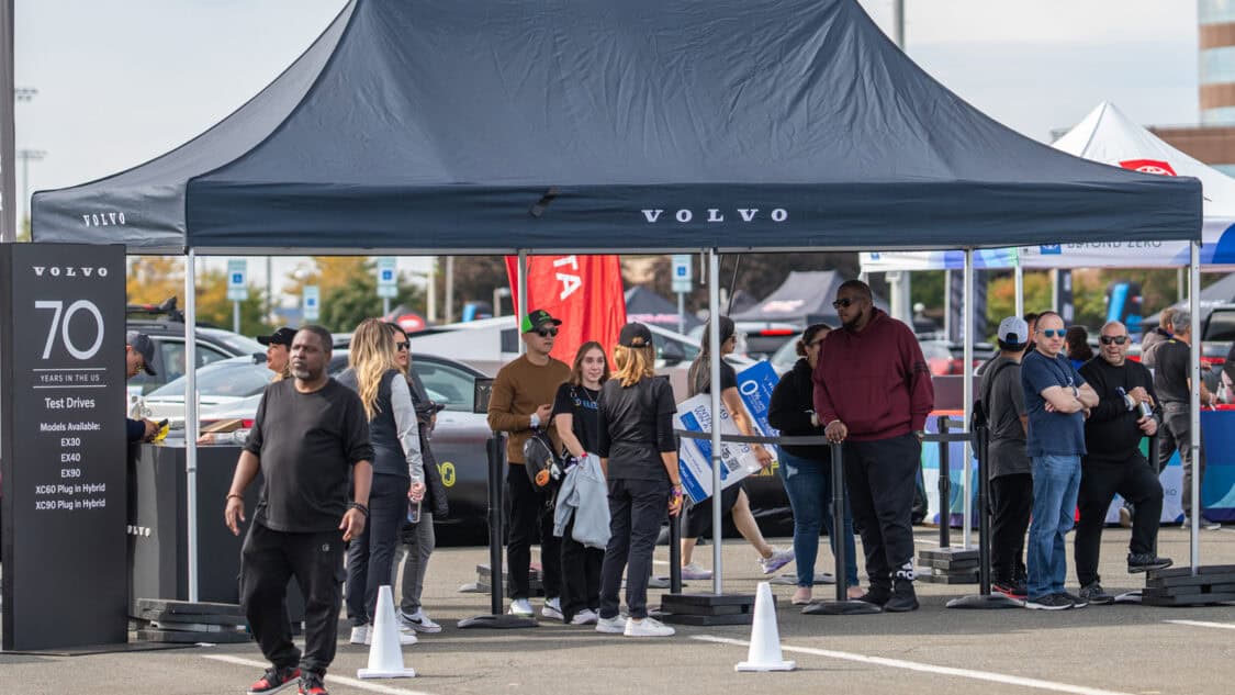 Volvo electric vehicle test drive area at Electrify Expo with attendees waiting under a Volvo canopy
